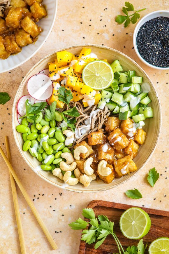 Kleurrijke bowl met sobanoedels, edamameboontjes en sinaasappeltofu